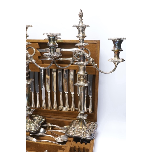 415 - An oak cased canteen containing Sheffield Super stainless flatware and a pair of plated candelabra... 