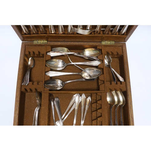 415 - An oak cased canteen containing Sheffield Super stainless flatware and a pair of plated candelabra... 