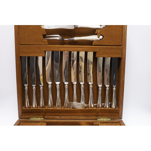 415 - An oak cased canteen containing Sheffield Super stainless flatware and a pair of plated candelabra... 