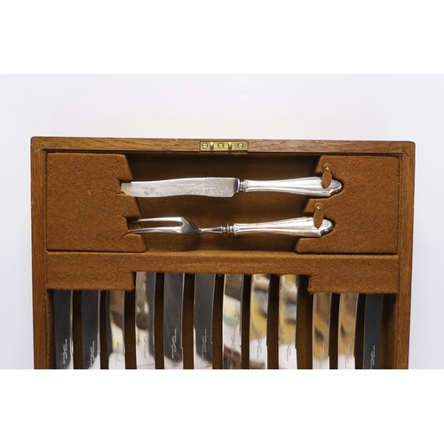 415 - An oak cased canteen containing Sheffield Super stainless flatware and a pair of plated candelabra... 