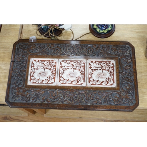 489 - A Victorian carved oak stand inset with there floral tiles, 69cm wide