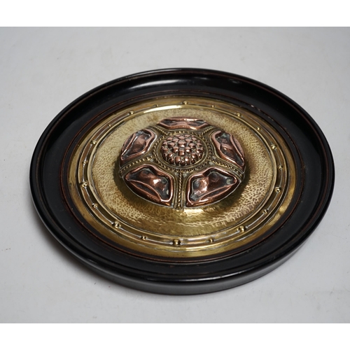 518 - An Arts and Crafts brass and copper roundel, in the manner of Archibald Knox, monogrammed CA, ebony ... 