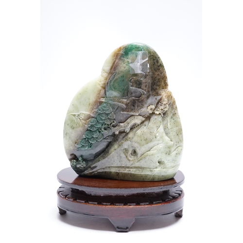 550 - A Chinese jadeite boulder carving on hardwood stand, 17cm high