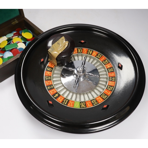 565 - A vintage roulette wheel with gaming counters etc.