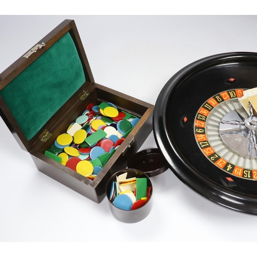 565 - A vintage roulette wheel with gaming counters etc.