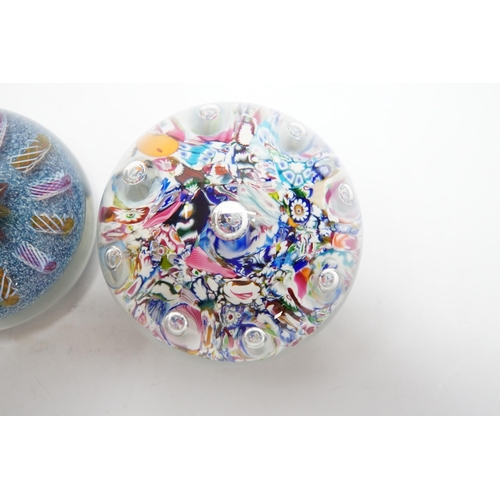 606 - Two Paul Ysart glass paperweights, comprising a purple flower and latticino spoke on a blue jasper g... 