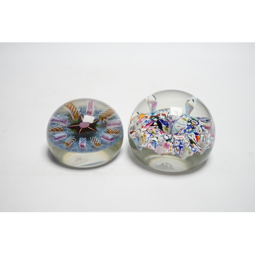 606 - Two Paul Ysart glass paperweights, comprising a purple flower and latticino spoke on a blue jasper g... 