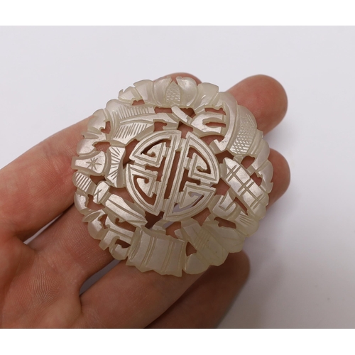 626 - A Chinese carved disc, possibly jade, 5.5cm in diameter