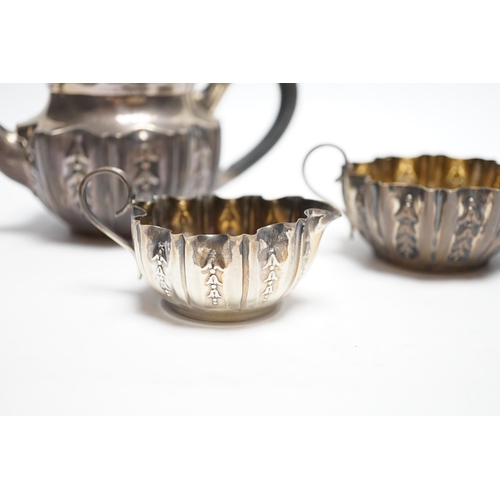 874 - A late Victorian bachelor's repousse silver three piece tea set, Sheffield, 1894/5, gross 11.3oz.... 