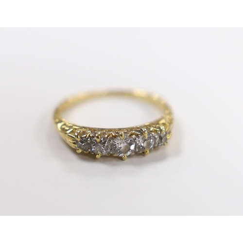 906 - An early 20th century yellow metal and graduated five stone diamond set half hoop ring, size I, gros... 