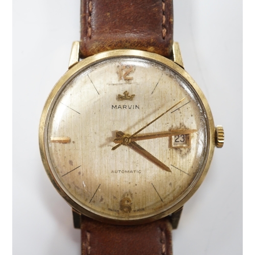 958 - A gentleman's 9ct gold Marvin automatic wrist watch, with date aperture, on a leather  strap.