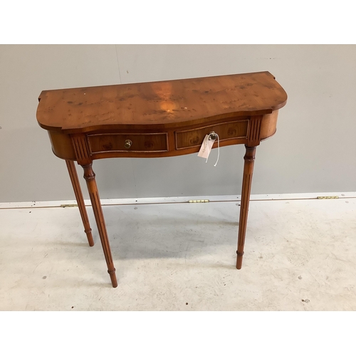 1028 - A reproduction yew wood two drawer serpentine side table, width 80cm, depth 34cm, height 73cm