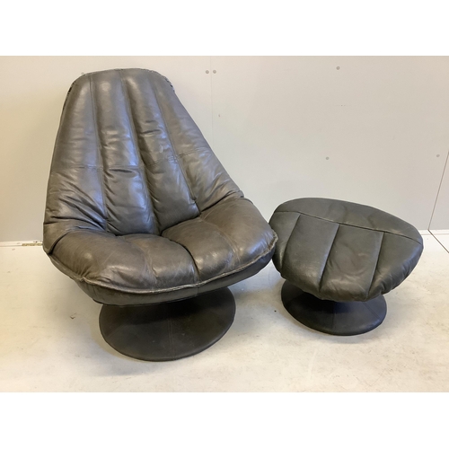 1039 - A mid century black leather revolving armchair, width 82cm, height 95cm and footstool