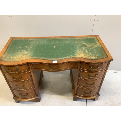 1073 - A reproduction walnut serpentine kneehole desk, width 115cm, depth 53cm, height 75cm