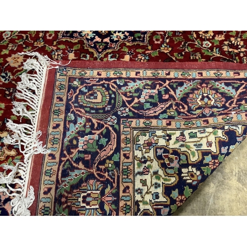 1084 - A Tabriz style burgundy ground rug, 224 x 155cm