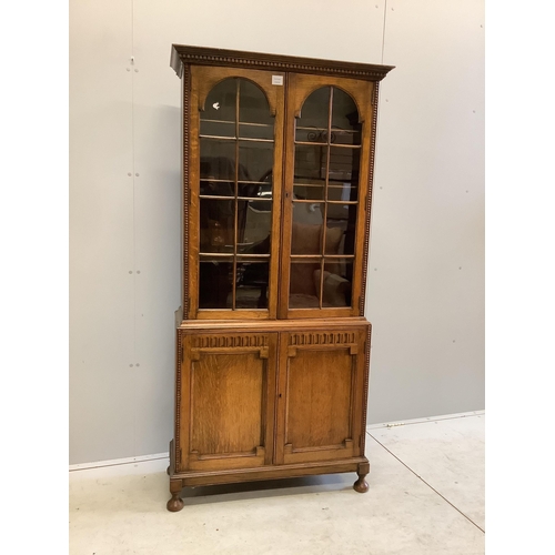 1108 - An early 20th century Jacobean Revival oak bookcase cupboard, width 84cm, depth 31cm, height 175cm... 