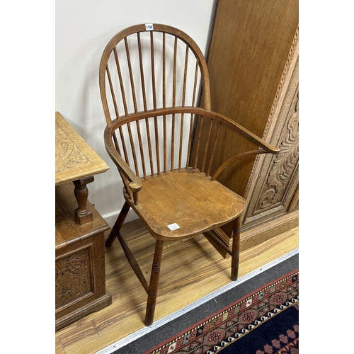 1150 - An elm and beech Windsor comb back elbow chair, width 65cm, depth 42cm, height 108cm