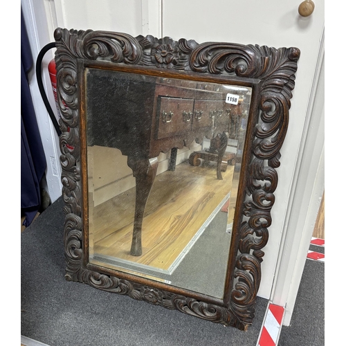 1158 - An early 20th century carved oak rectangular wall mirror, width 68cm, height 86cm