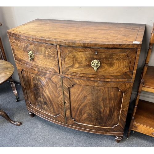 1179 - A George IV flame mahogany bowfront press cupboard, width 115cm, depth 61cm, height 108cm