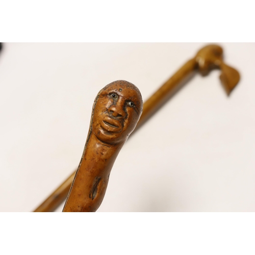 1424 - Two walking canes including a Greek olive wood example with carved head handle, largest 89cm in leng... 