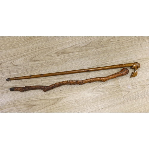 1424 - Two walking canes including a Greek olive wood example with carved head handle, largest 89cm in leng... 