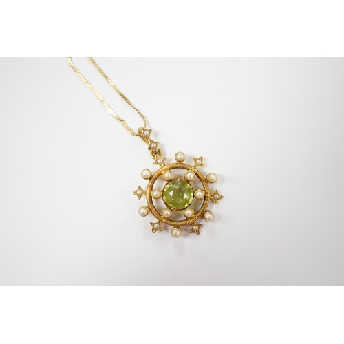 1956 - An Edwardian yellow metal, peridot and seed pearl cluster set 'wheel' pendant, overall 30mm, on a la... 