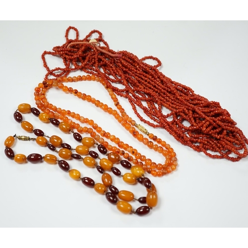 1987 - A single strand amber and simulated cherry amber bead necklace, 72cm, gross weight 33 grams, togethe... 