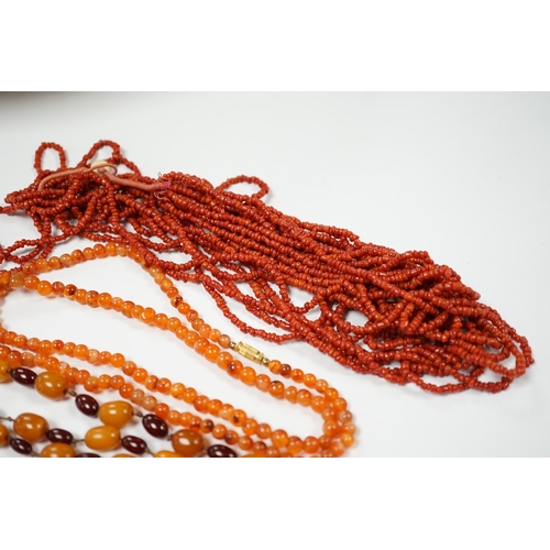 1987 - A single strand amber and simulated cherry amber bead necklace, 72cm, gross weight 33 grams, togethe... 