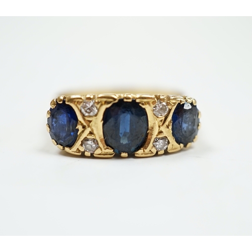 1992 - An 18ct and three stone sapphire set half hoop ring, with diamond chip spacers, size O, gross weight... 