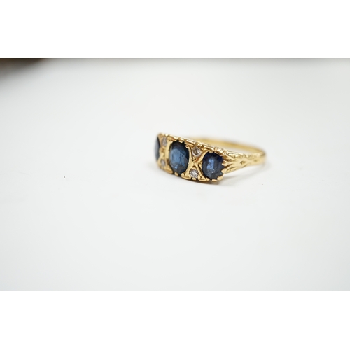 1992 - An 18ct and three stone sapphire set half hoop ring, with diamond chip spacers, size O, gross weight... 