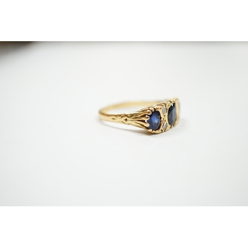 1992 - An 18ct and three stone sapphire set half hoop ring, with diamond chip spacers, size O, gross weight... 