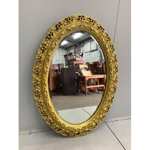 1049 - An oval gilt composition wall mirror, width 82cm, height 114cm