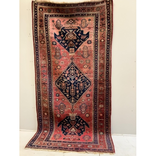 1192 - An Heriz red ground medallion rug with triple medallions on a brick red ground, multi bordered, 280 ... 