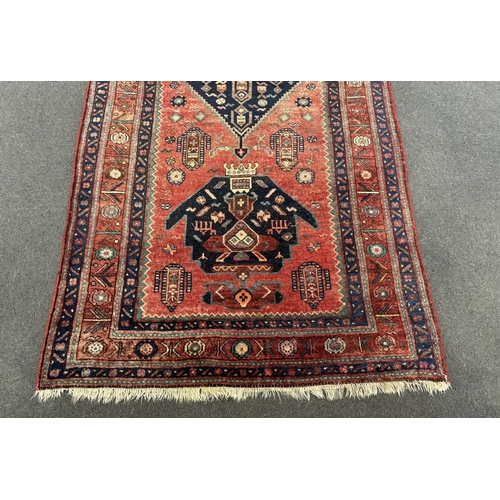 1192 - An Heriz red ground medallion rug with triple medallions on a brick red ground, multi bordered, 280 ... 