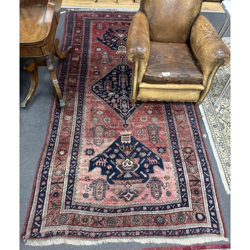 1192 - An Heriz red ground medallion rug with triple medallions on a brick red ground, multi bordered, 280 ... 