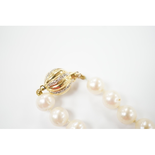 1953 - A single strand cultured pearl necklace with 18K and diamond chip set spherical clasp, 49cm.