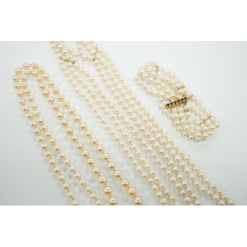 1956 - Two Cultured pearl necklaces including a triple strand with yellow metal and sapphire set clasp, 46c... 