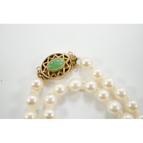 1957 - A single strand cultured pearl necklace, with 14k and jade set clasp, 40cm.