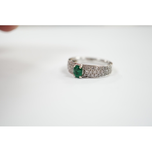 1979 - A modern 18ct white gold and single stone oval cut emerald set ring, with pave set diamond shoulders... 