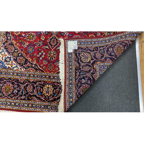 181 - A Tabriz burgundy ground carpet, 292 x 216cm