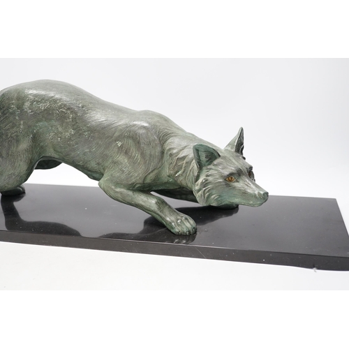 284 - A bronzed metal model of a stalking fox, on black marble plinth, 62cm