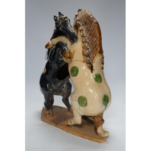 287 - A Chinese sancai glazed group of fighting horses, Tang or later, 39cm high