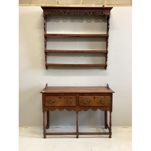 152 - A George III style oak dresser, of small proportions, fitted with twin drawers and shaped apron, rai... 