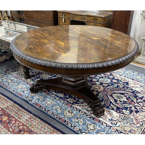 179 - A William IV circular rosewood centre table, the tilt top with lappet carved edge on single tapered ... 