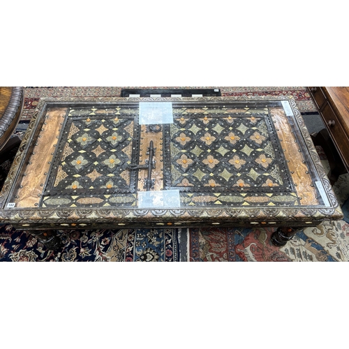 182 - A copper mounted Moroccan door, now as a coffee table, width 153cm, depth 78cm, height 57cm