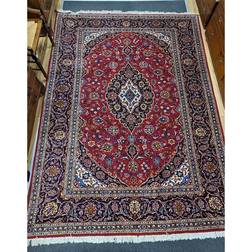 184 - A Tabriz burgundy ground carpet, 292 x 216cm