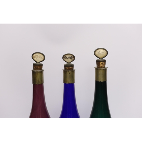 472 - A silver mounted glass claret jug and three coloured glass bottles, 37cm