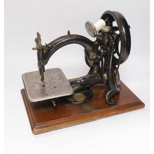 545 - A Victorian Wilcox and Gibbs sewing machine and a smaller sewing machine, 28cm high