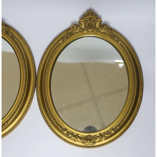 550 - A pair of small oval giltwood and composition wall mirrors, 35cm high