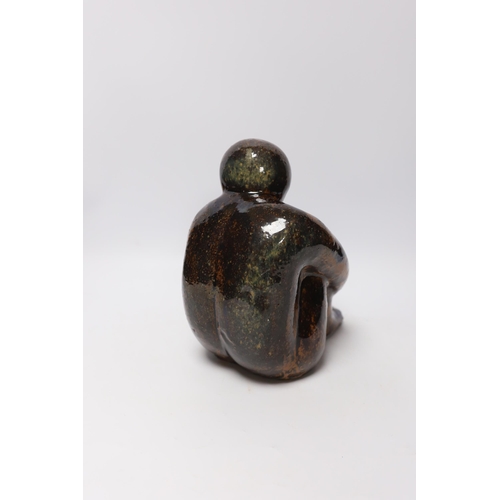 566 - A 20th century tenmoko glazed pottery figure of a seated figure, 22cm